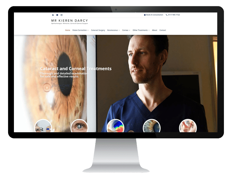 A computer screen displays an ophthalmology website design Surrey, featuring a male doctor in blue scrubs, with a large close-up image of an eye and text about cataract and corneal treatments.