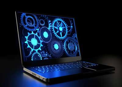 A laptop on a dark surface displays glowing blue gears and cogs, symbolizing technology or digital processes—a fitting image for a Surrey SEO Agency focused on innovative software solutions. The keyboard is illuminated by the screen’s blue light.