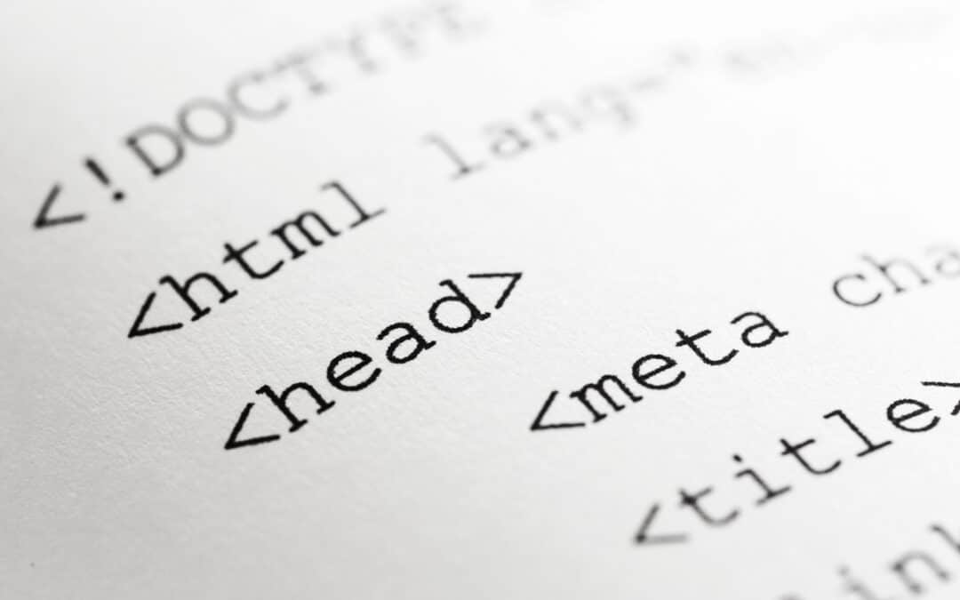 Close-up of a printed HTML document displaying tags like html, head, meta, and title, with the word head in focus—highlighting SEO Meta Tags and best practices for web development.